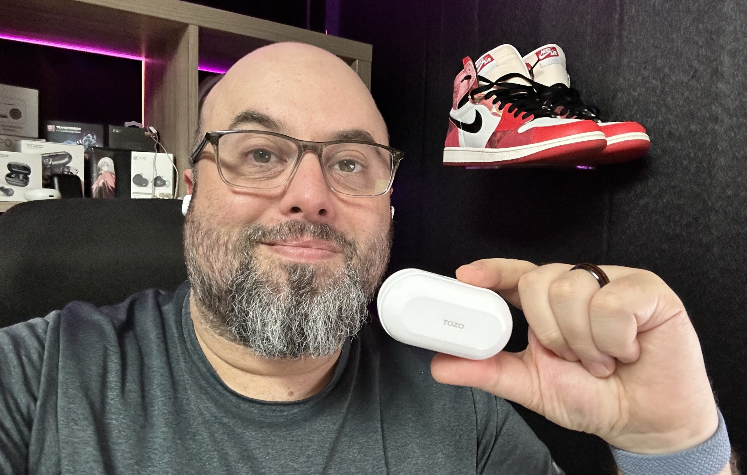 Mr. Audio Feedback holding a pair of TOZO NC9 earbuds.